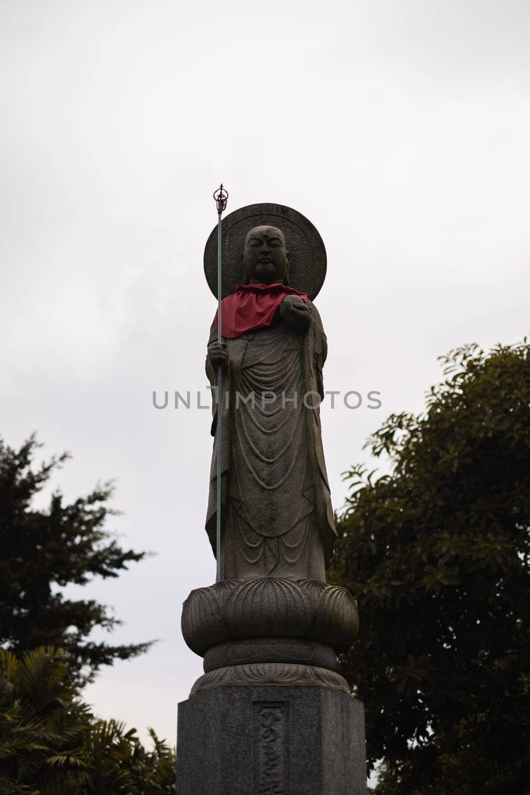 Singapore - July 9 2023: Stone Monk Statue With Red Scarf