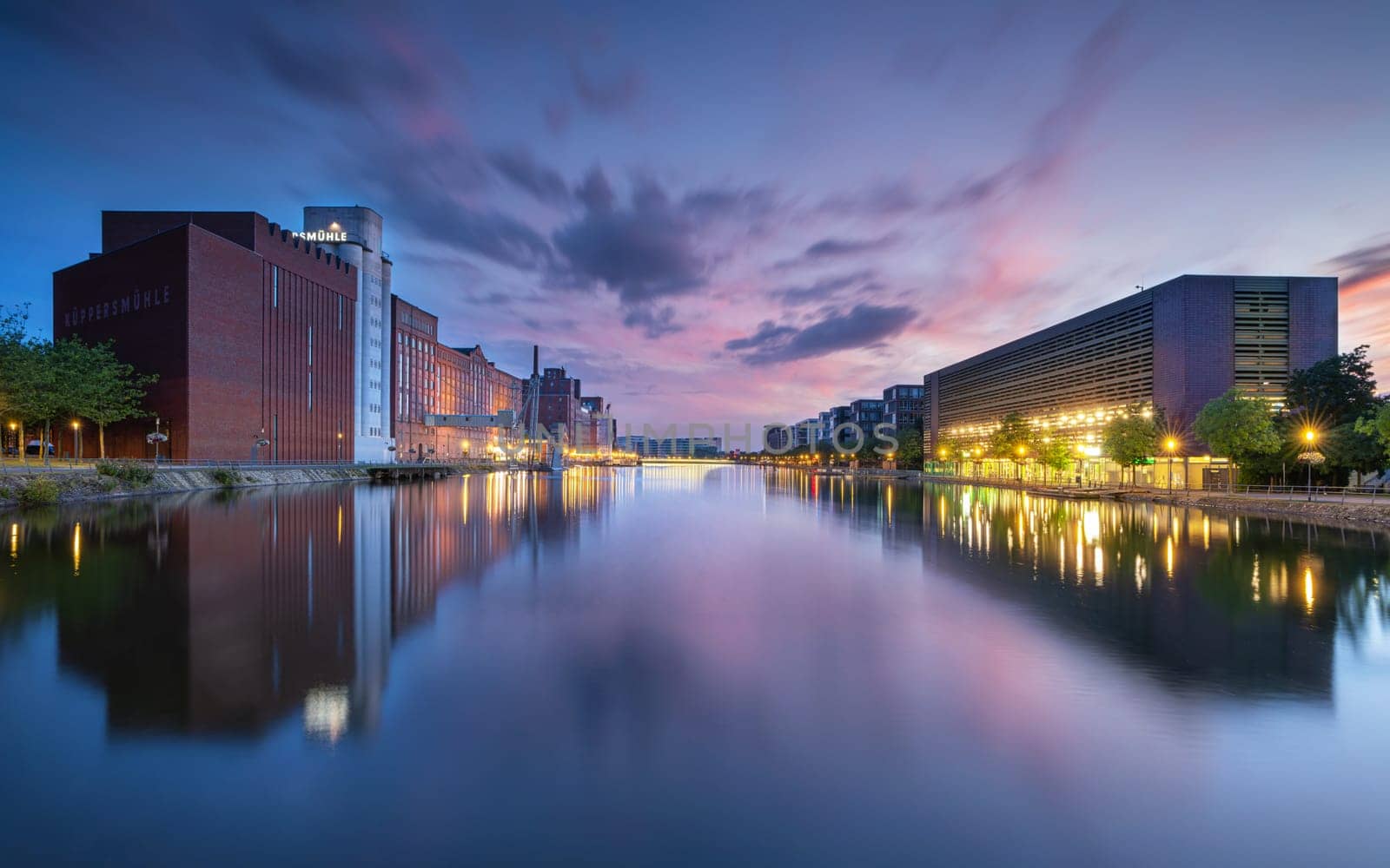 DUISBURG, GERMANY - AUGUST 12, 2023: Panoramic image of historical city harbor of Duisburg during evening light on August 12, 2023 in Germany