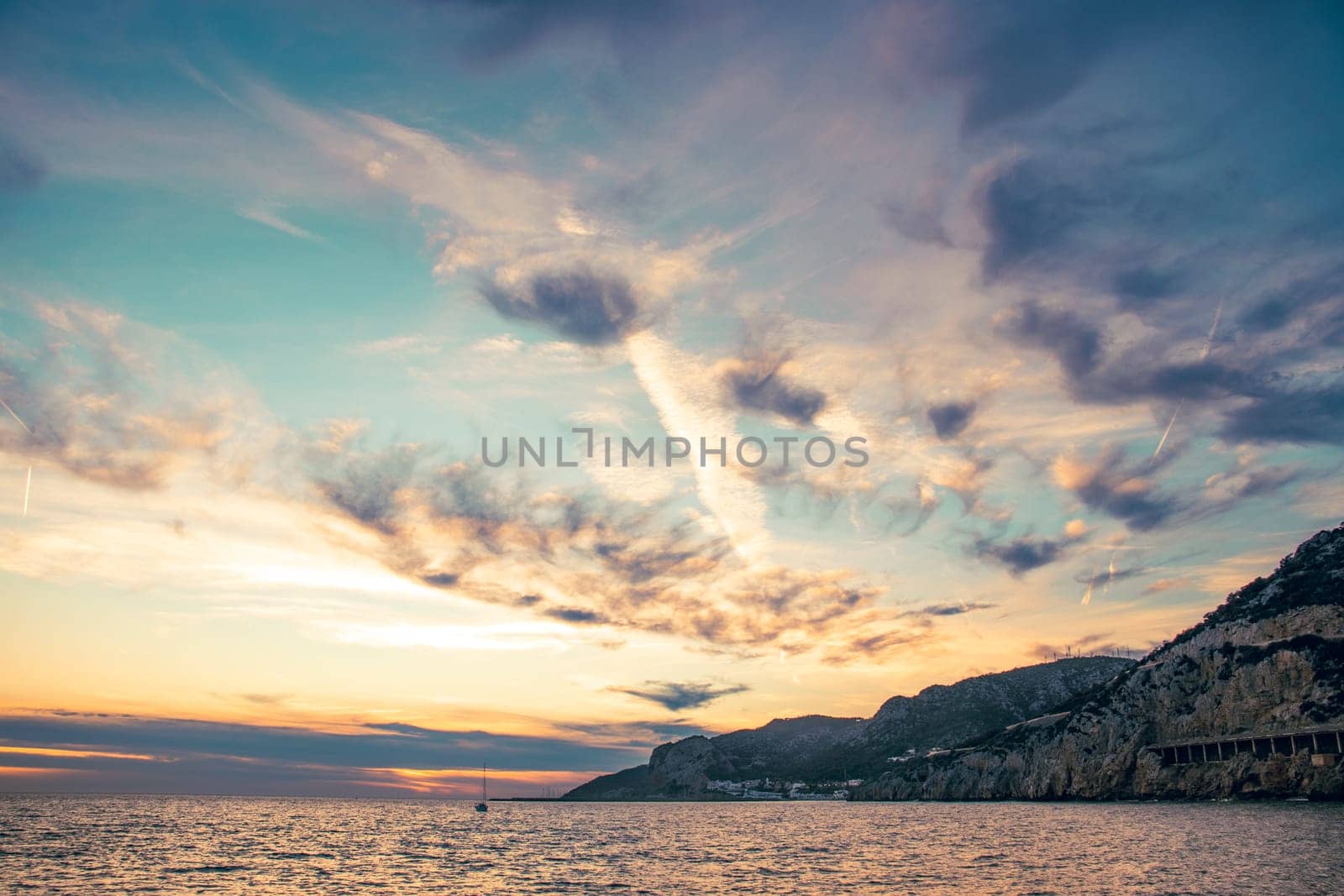 Amazing panoramic landscape of rocky shore photo. Sunrise sundown sky background with colorful clouds. Mediterranean sea. Beach concept photo. Bright seaside dusk. High quality picture for wallpaper