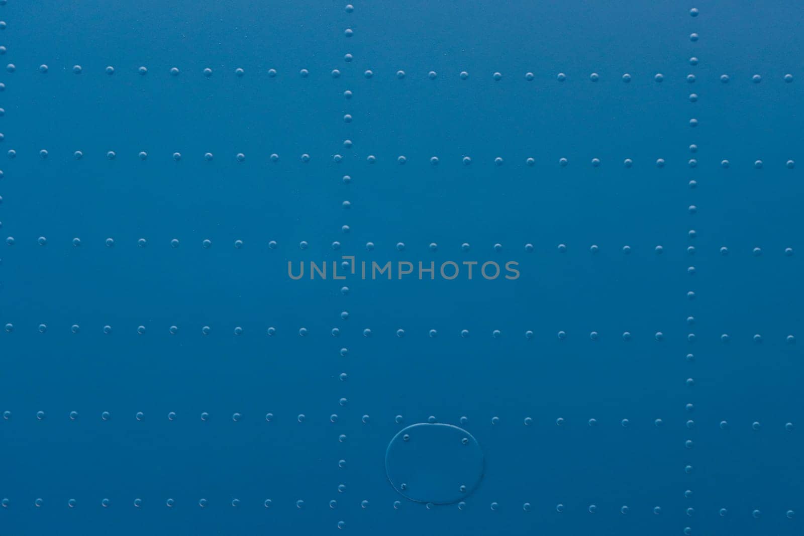 Riveted metal from an aircraft. Abstract blue metal background with studs.