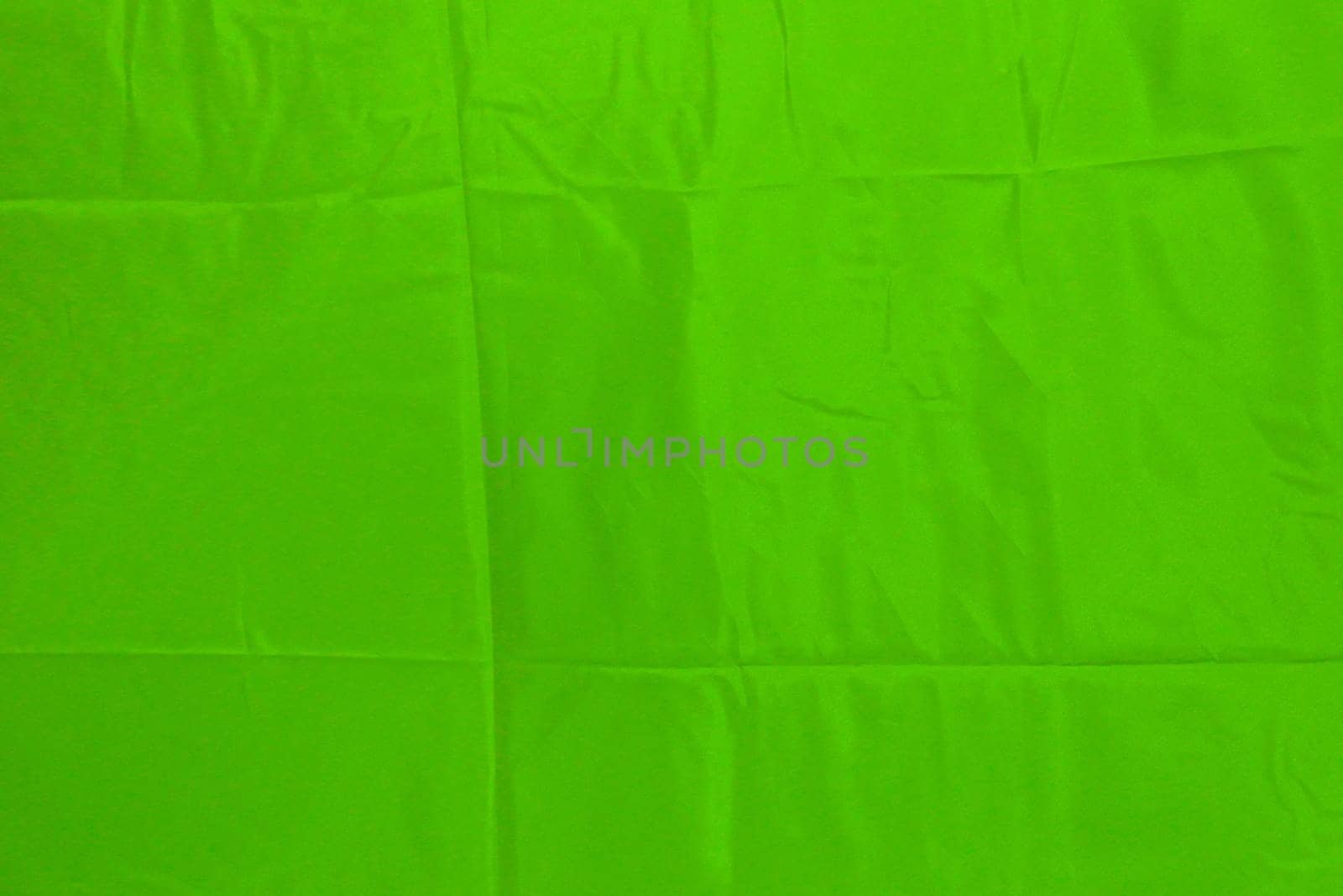 Green satin texture fabric shiny with pleats. Green texture for copy space design.