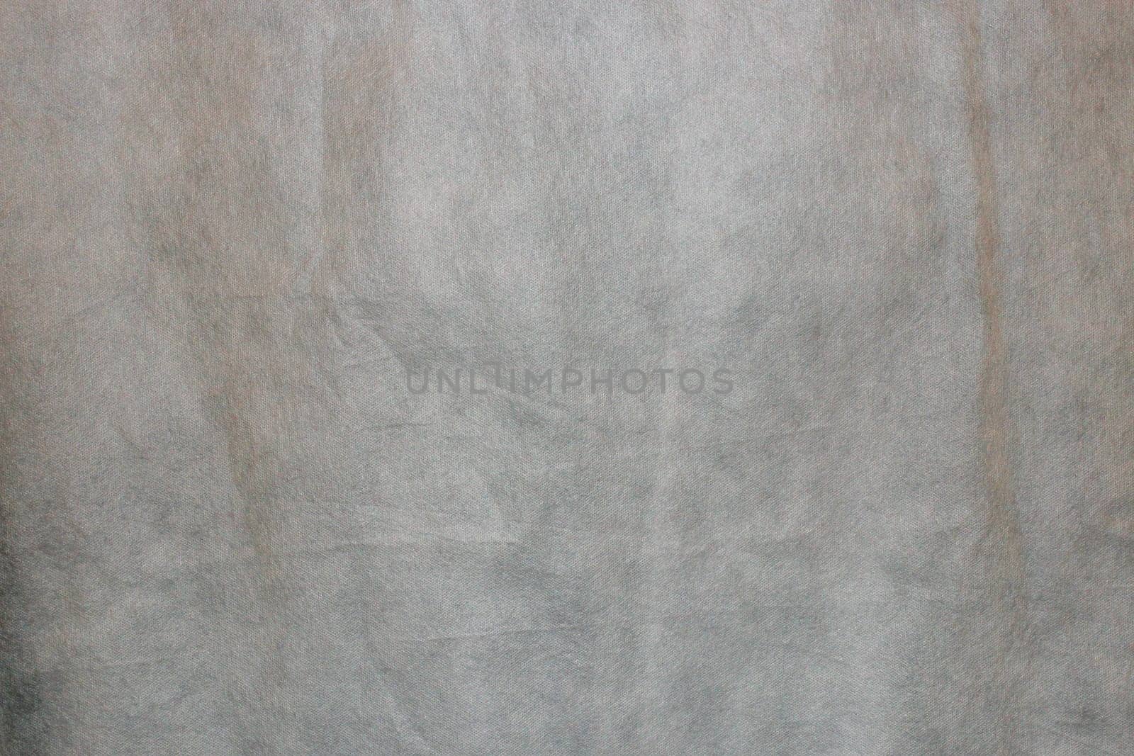 Abstract Spunchbond gray background. Texture for a design made of old outdated artificial gray fabric.