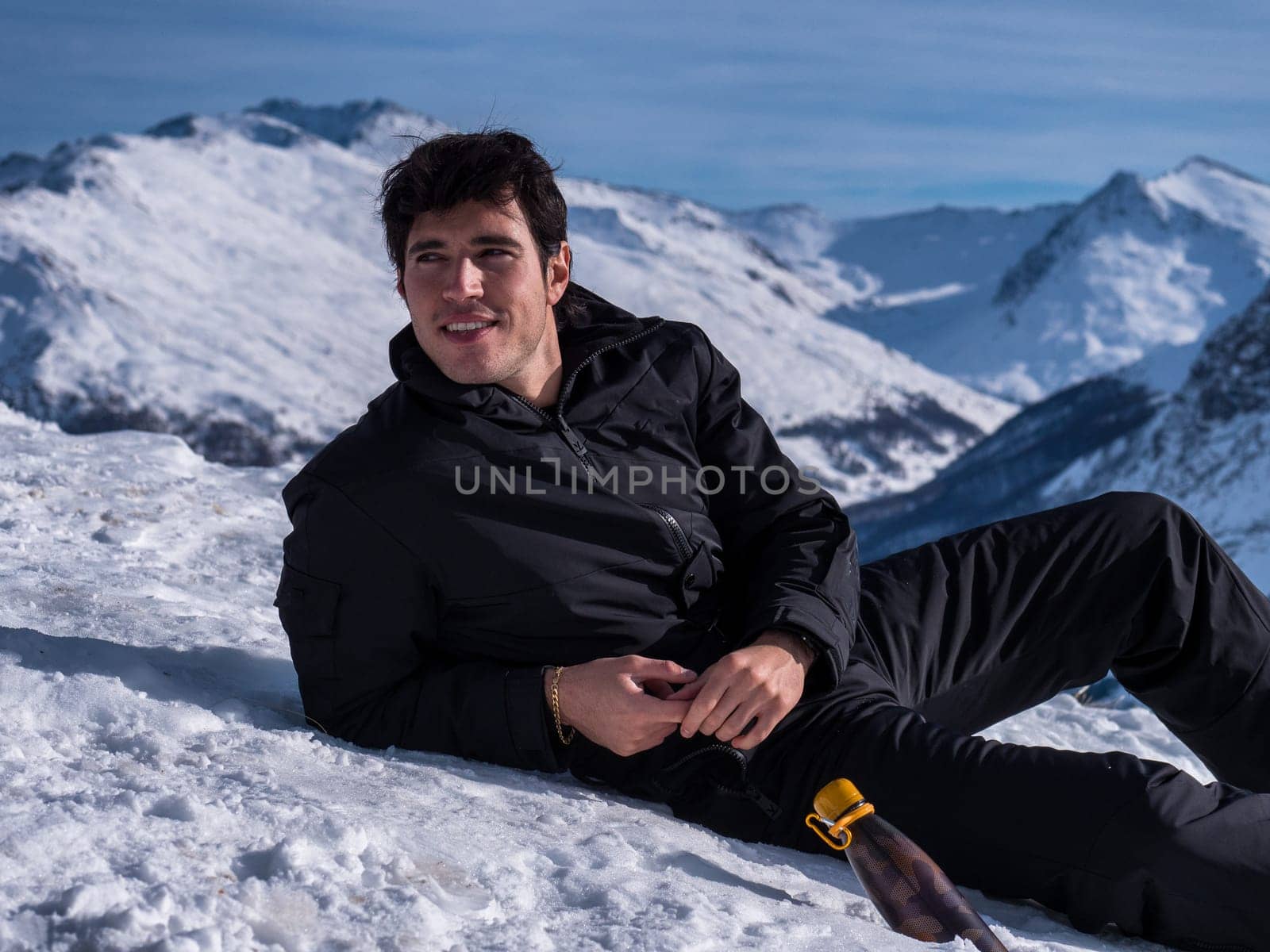 A man sitting on top of a snow covered mountain