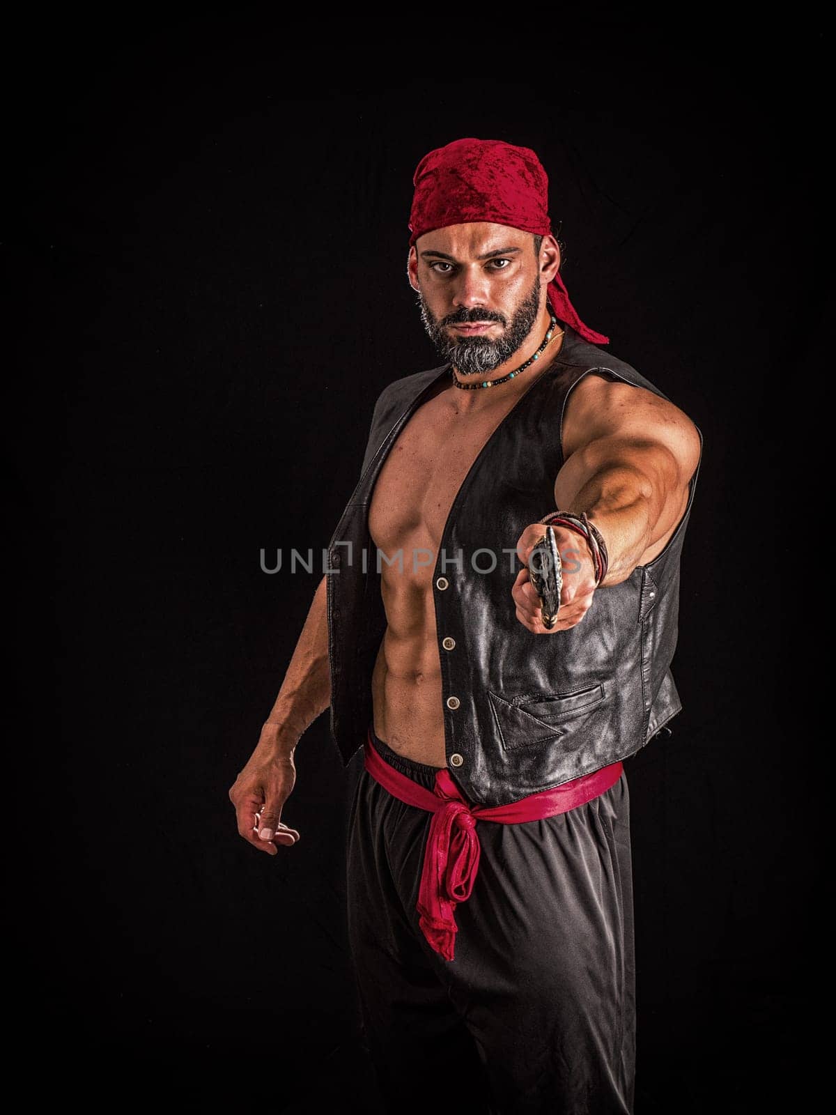 A muscular topless man with a red bandanna and pirate costume, standing in front of a white background. A Brave Soul in Crimson: A Male Bodybuilder with a Red Bandanna Standing Proudly Before a Black Background