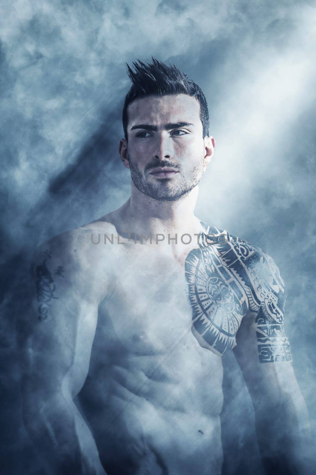 Photo of a muscular and attractive man showcasing his tattooed arm by artofphoto