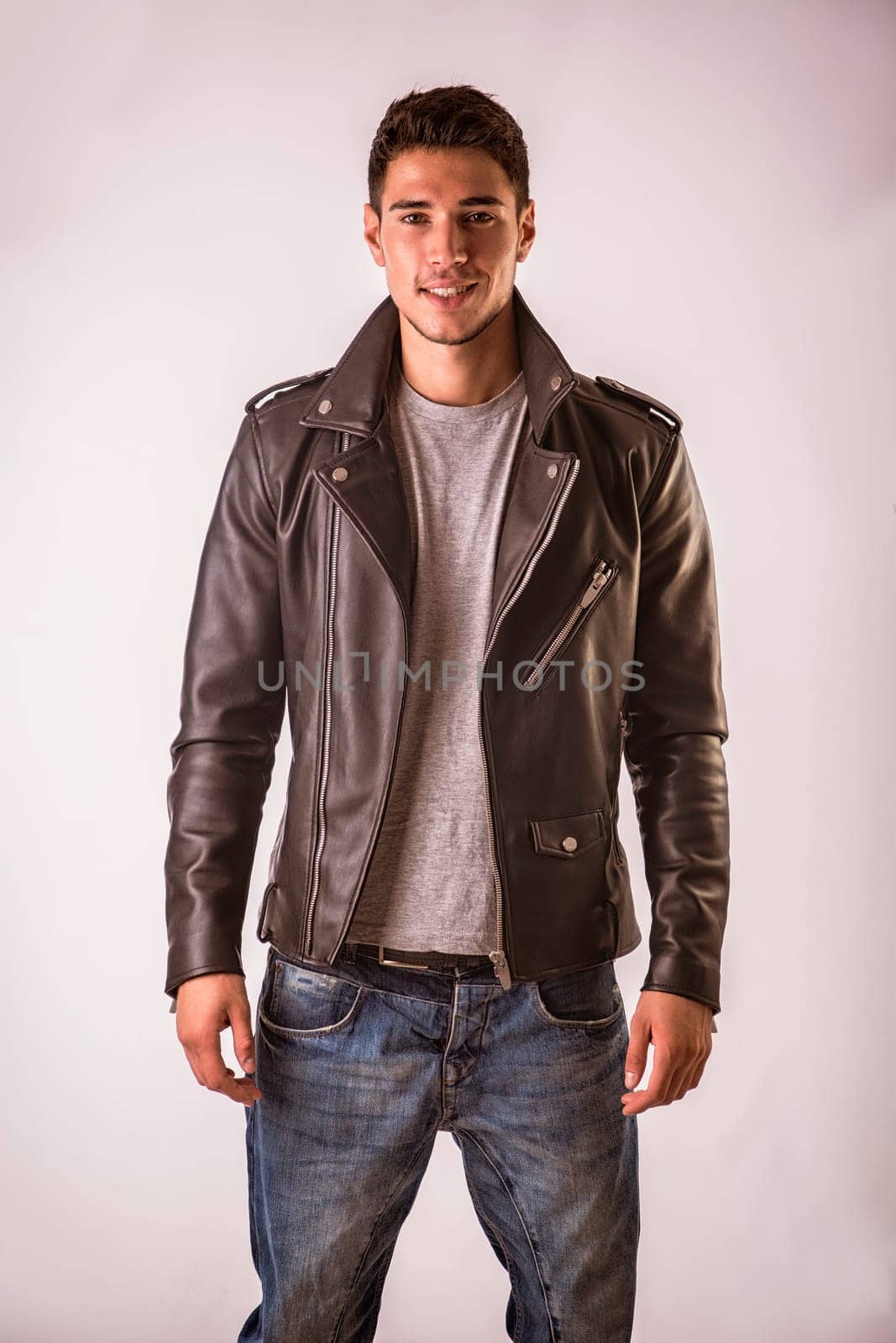 Young handsome man in studio shot, wearing black leather jacket by artofphoto