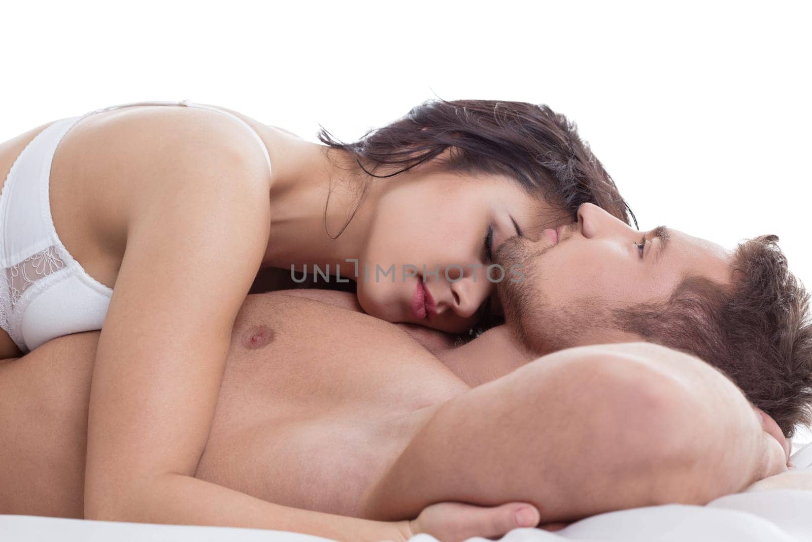Loving couple tenderly embracing while lying in bed
