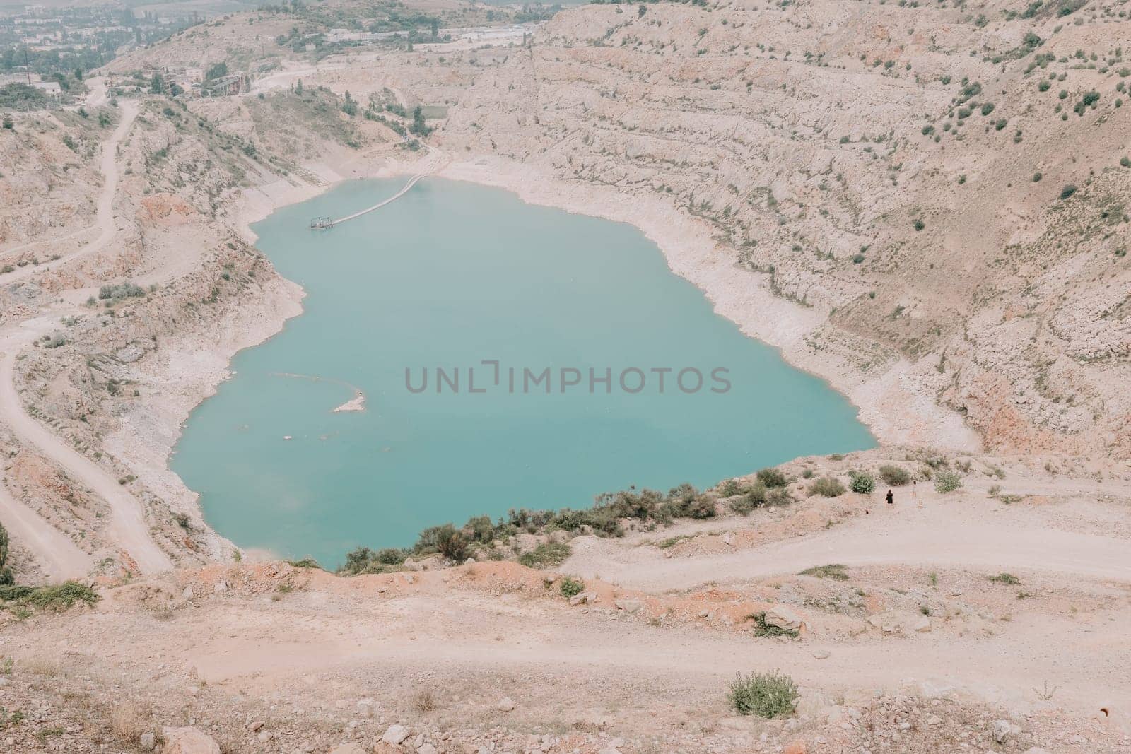 Woman travel portrait. Happy woman with long hair looking at camera and smiling. Close up portrait cute woman is posing on a heart shaped lake - travel destination by panophotograph