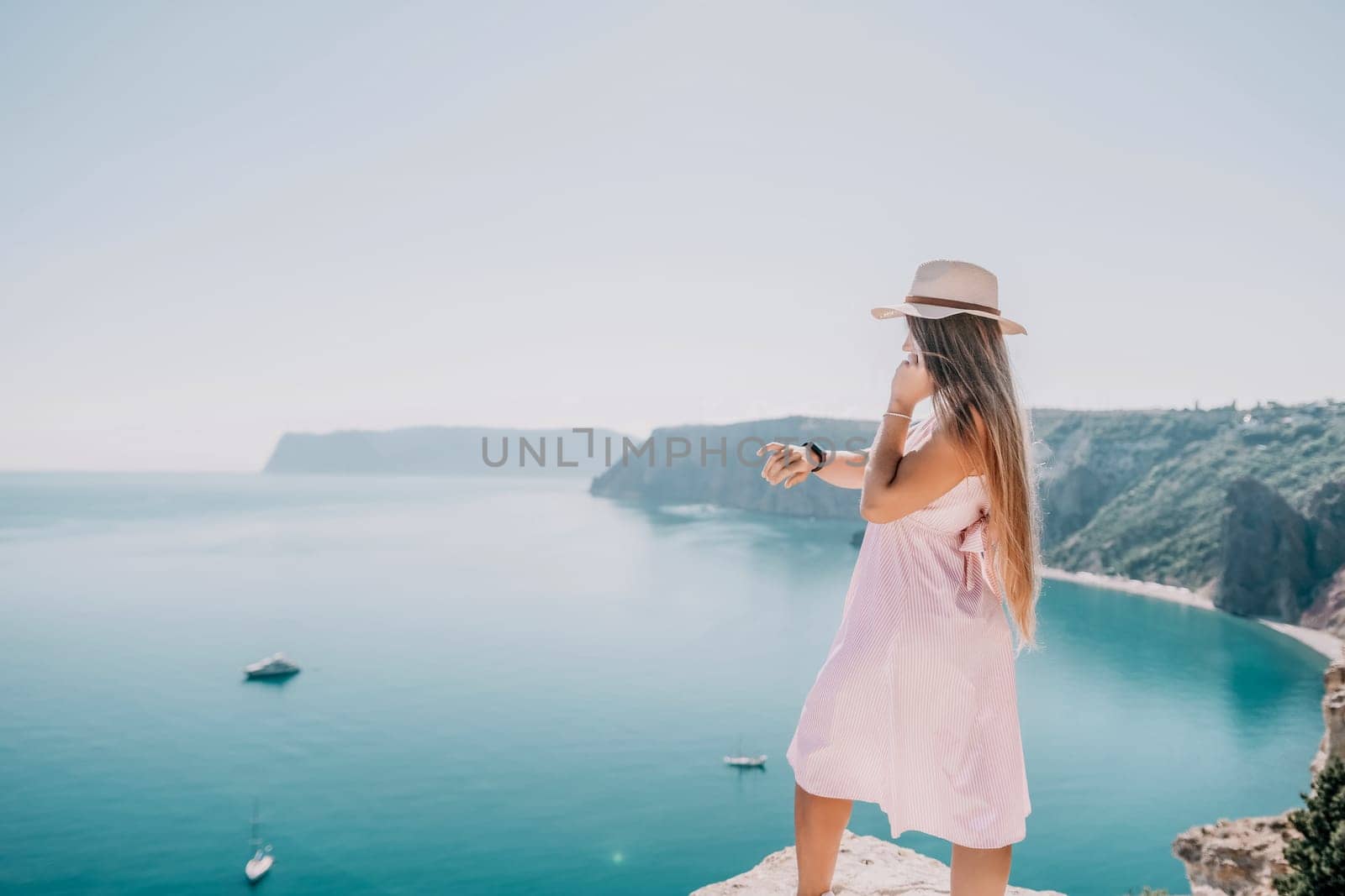 Woman sea laptop. Business woman in yellow hat freelancer with laptop working over blue sea beach. Girl relieves stress from work. Freelance, digital nomad, travel and holidays concept by panophotograph