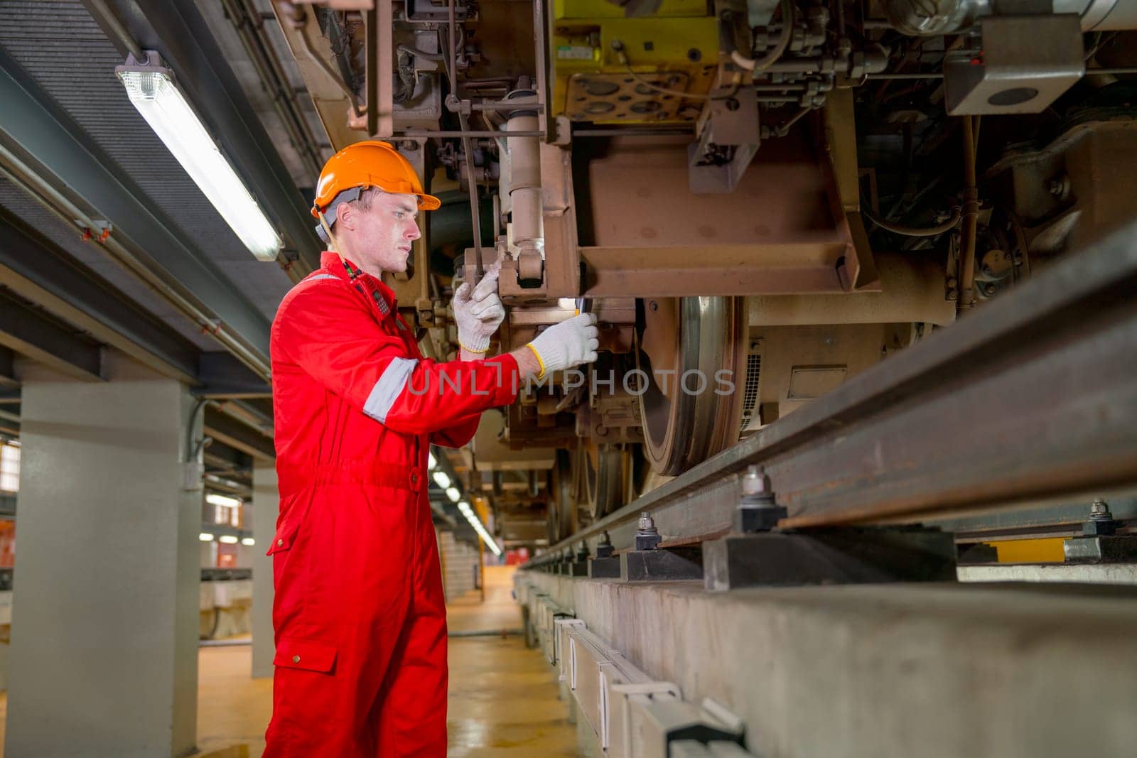 Professional technician worker hold light tube to check and maintenance part of train in electrical or metro train factory.