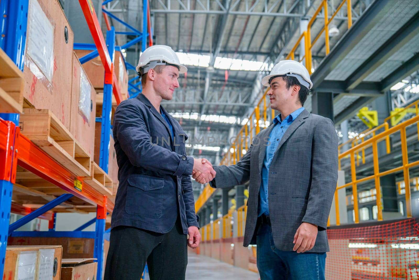 Professional business man or engineer shake hands for success of the project in factory industrial workplace or train factory.