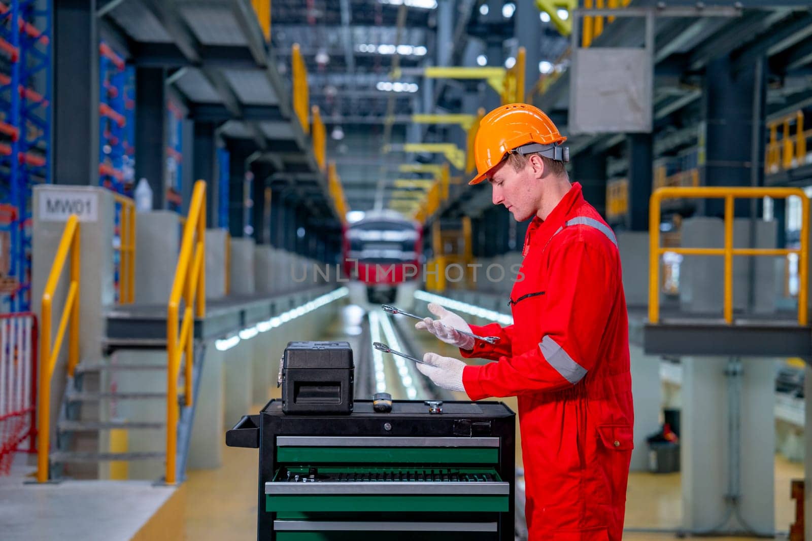 Professional technician worker with safety uniform check tools and equipment in the cabinet to prepare for check and maintenance in electrical or sky train factory.