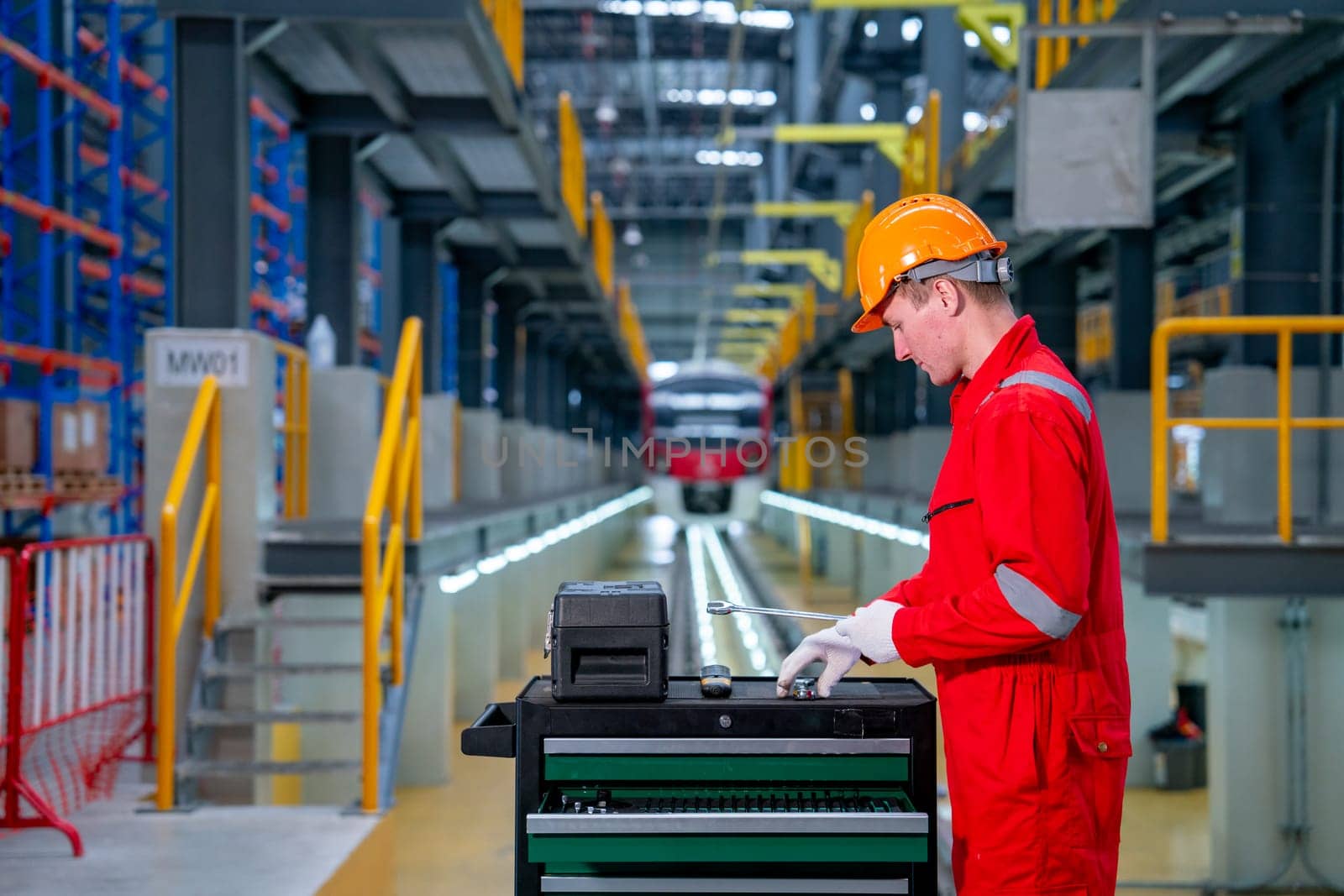 Professional technician worker with safety uniform check tools and equipment in the cabinet to prepare for check and maintenance in electrical or sky train factory.