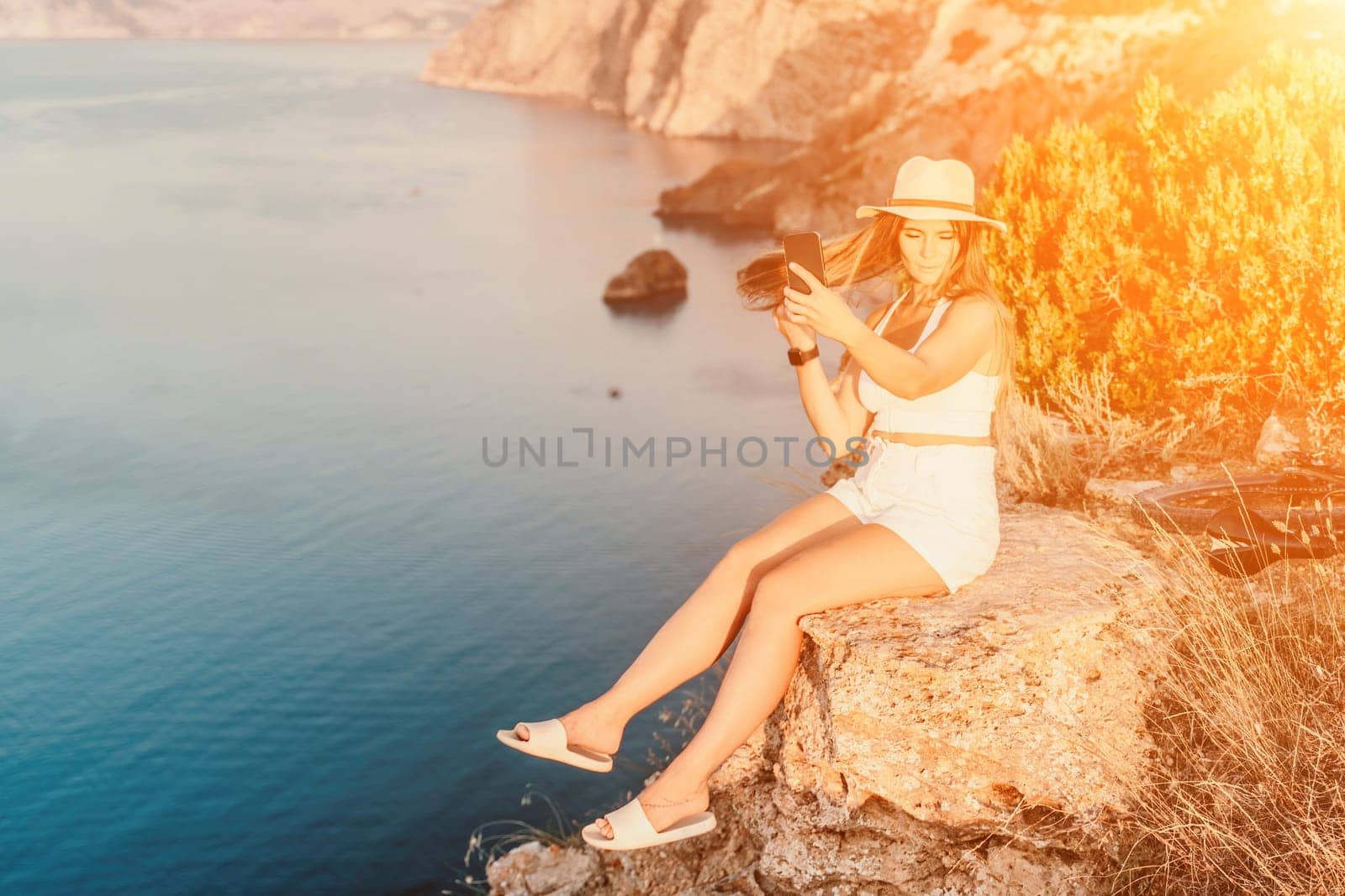 Selfie woman in cap and tank top making selfie shot mobile phone post photo social network outdoors on sea background beach people vacation lifestyle travel concept. by Matiunina