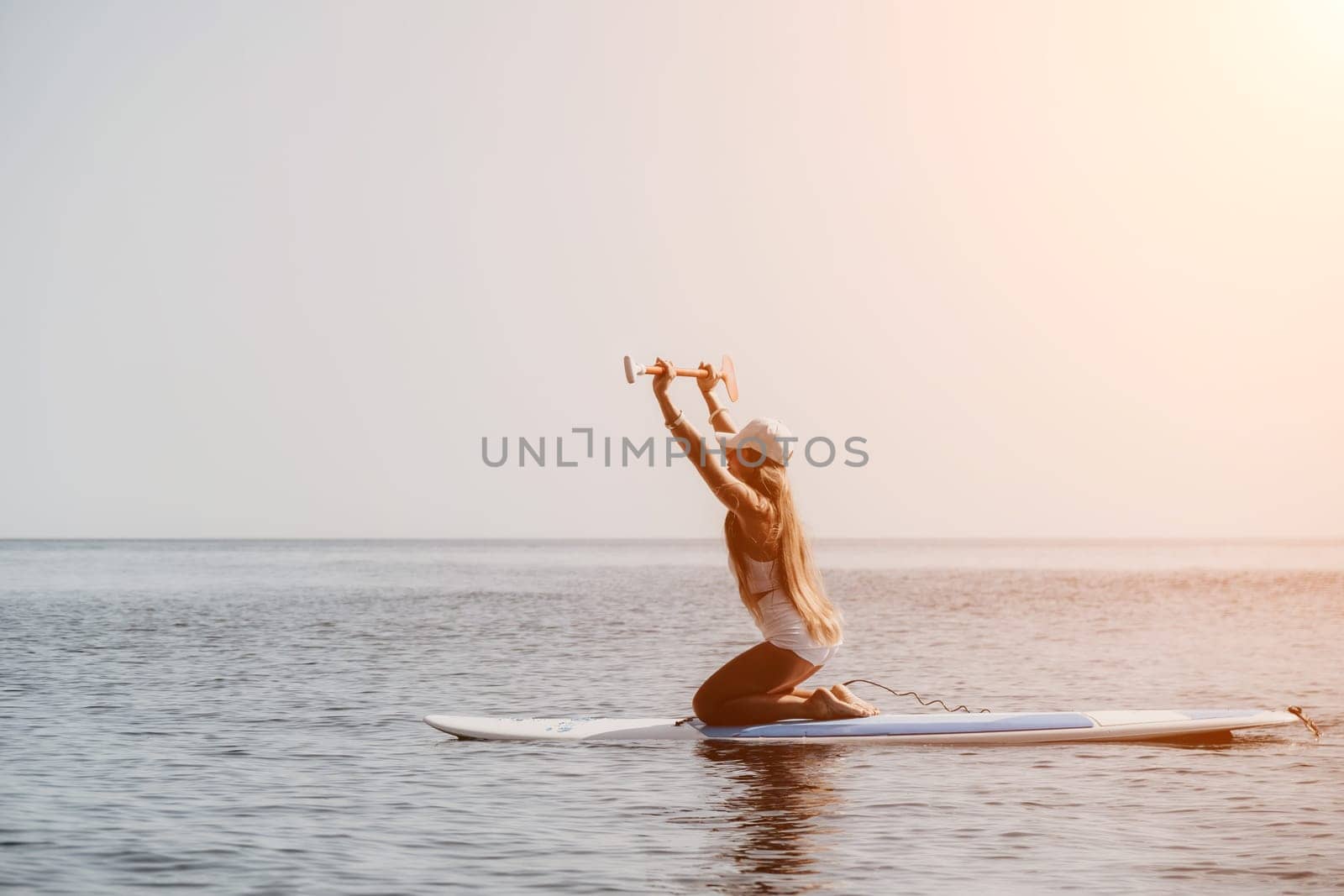 Woman sea sup. Close up portrait of happy young caucasian woman with long hair looking at camera and smiling. Cute woman portrait in bikini posing on sup board in the sea by panophotograph