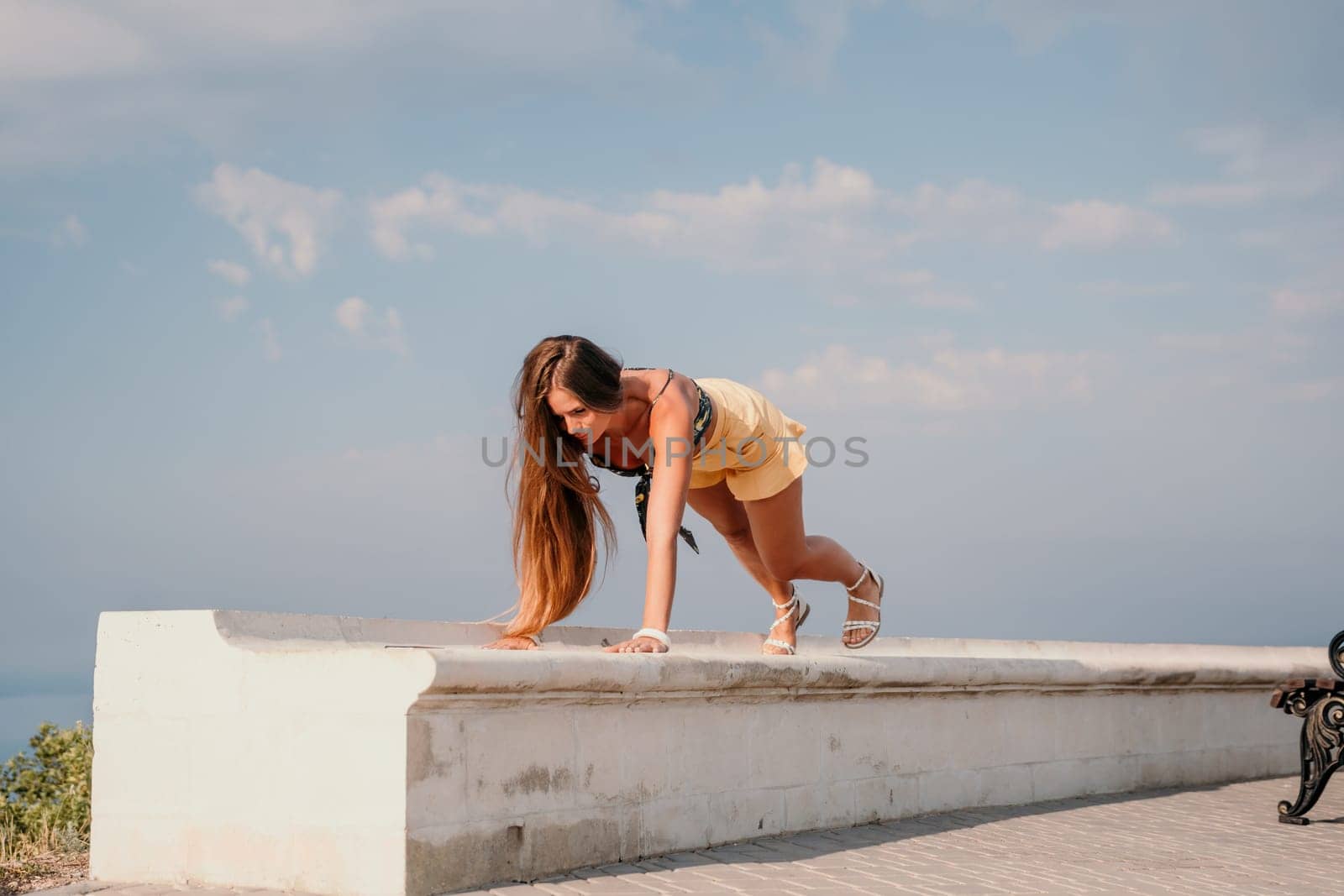 Woman park yoga. Side view of free calm bliss satisfied woman with long hair standing in morning park with yoga position against of sky by the sea. Healthy lifestyle outdoors in park, fitness concept