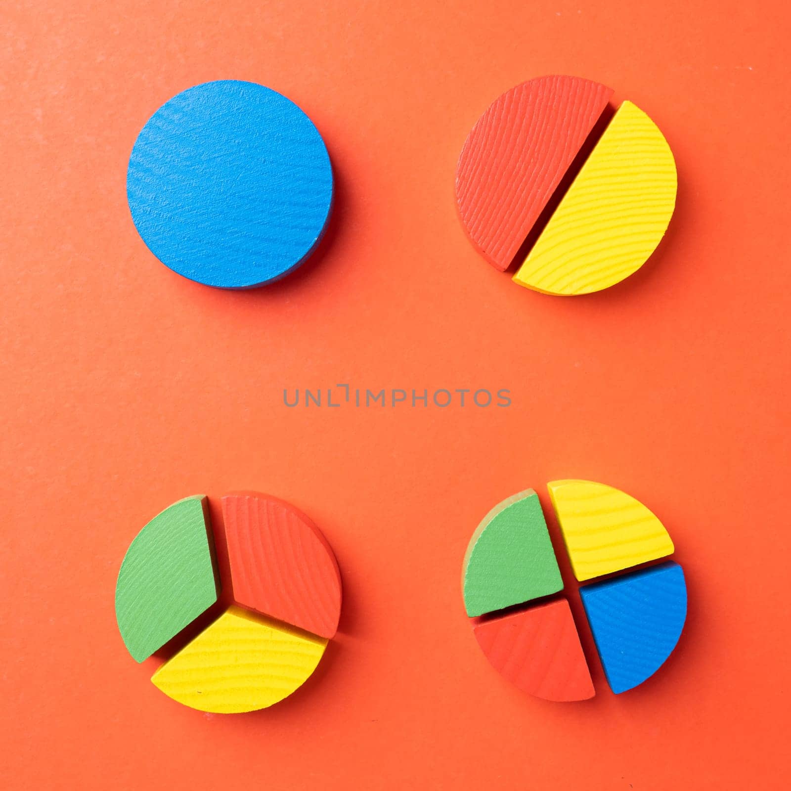 Colorful wooden pie chart pieces on bright red background
