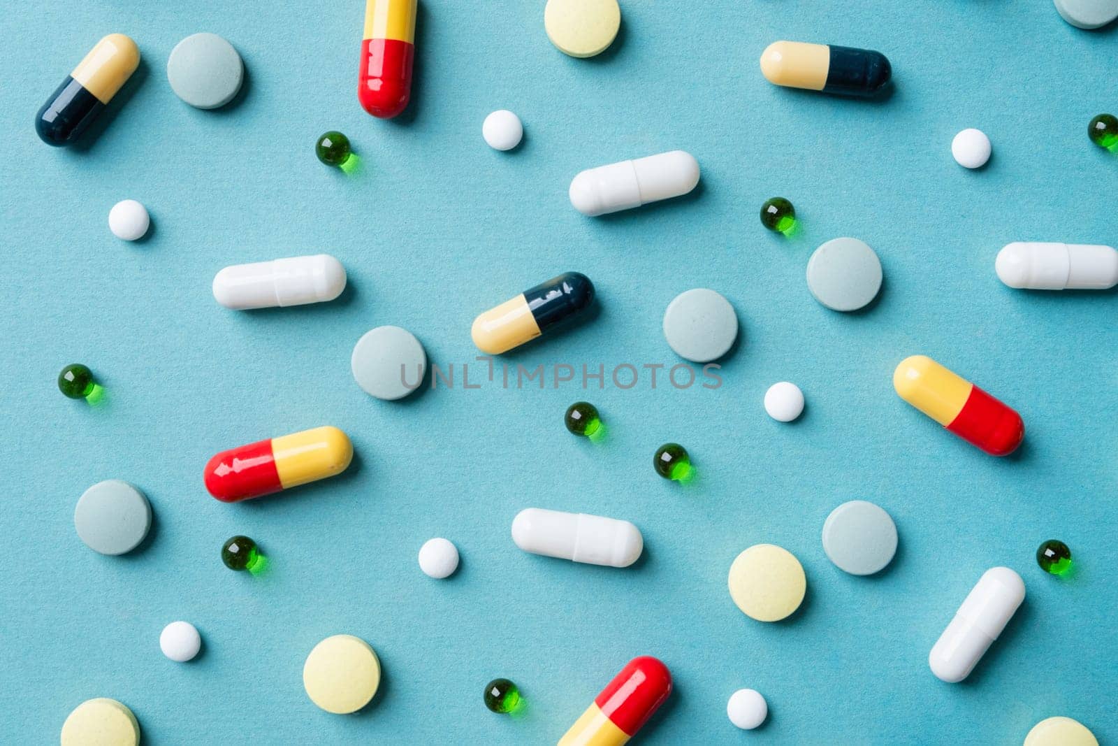 Different pills on color blue background, flat lay