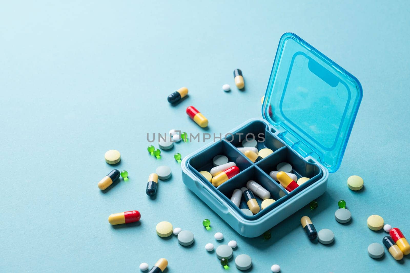 composition with pill box and pills on blue color background