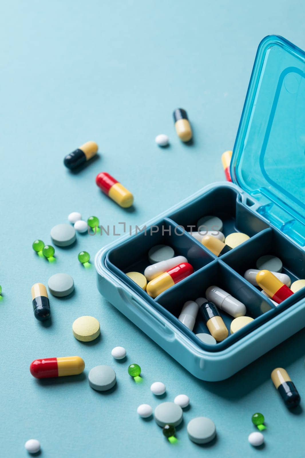 composition with pill box and pills on blue color background