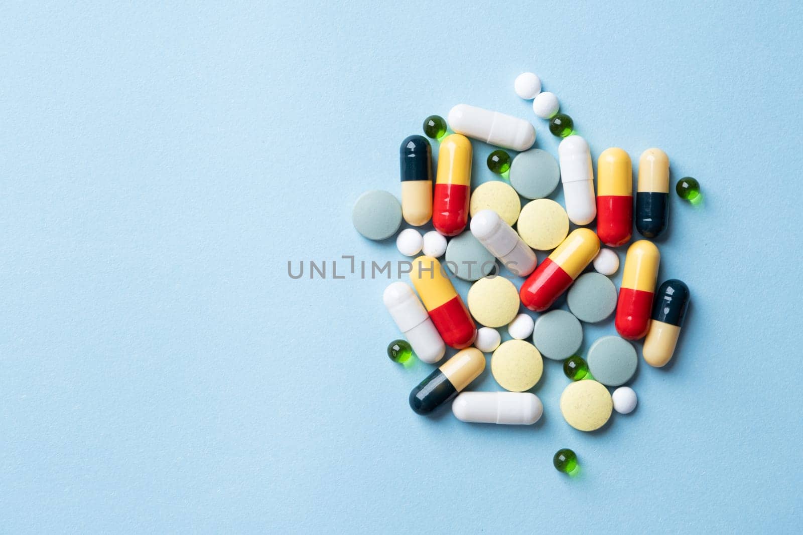 pile of Different pills on color blue background, flat lay