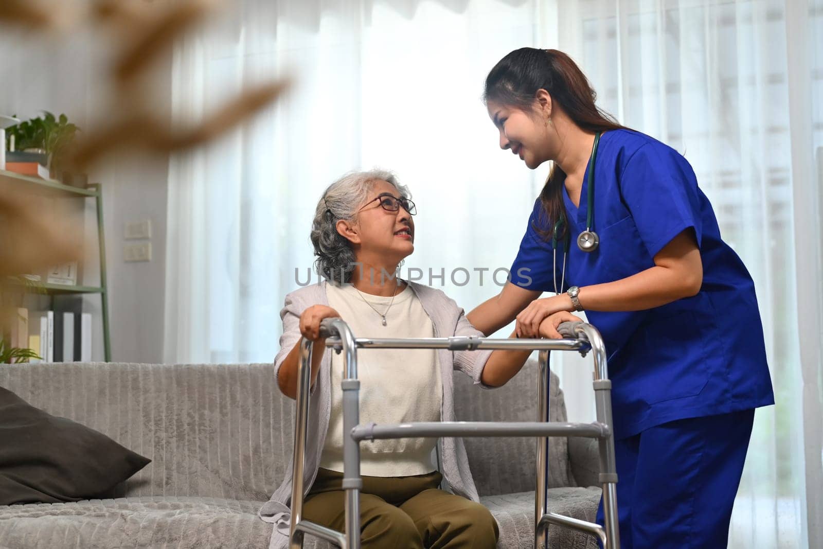 Caring healthcare worker talking while visiting senior woman patient at home. Healthcare concept. by prathanchorruangsak