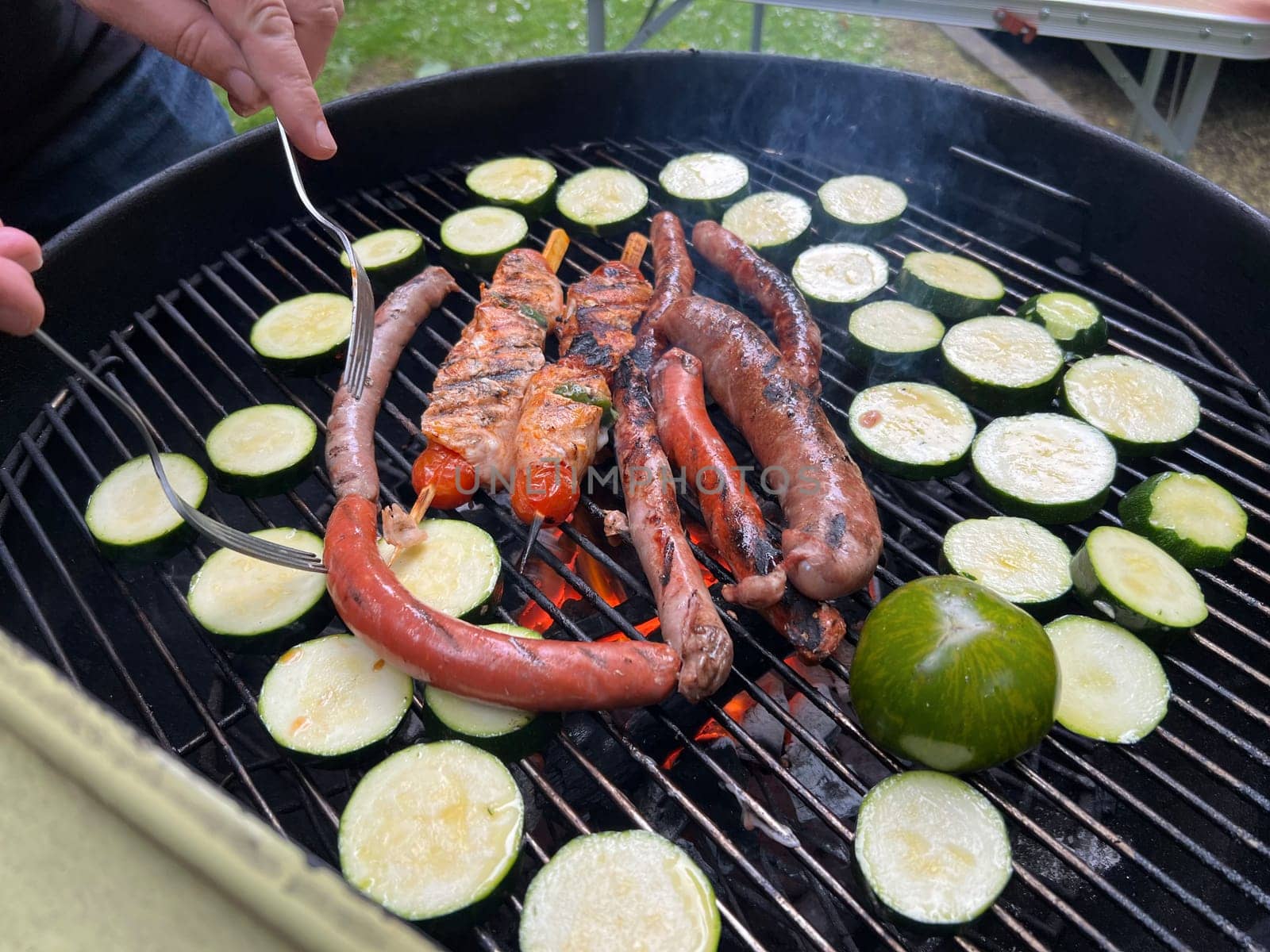 Meat and sausages with the vegetables on the barbecue grill