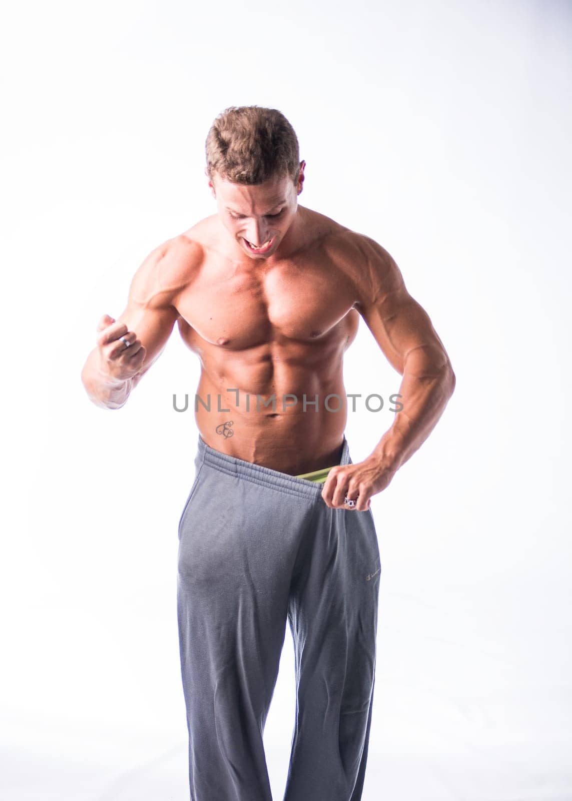 Shirtless Male Bodybuilder Has Lost Weight, Wearing Large Pants by artofphoto