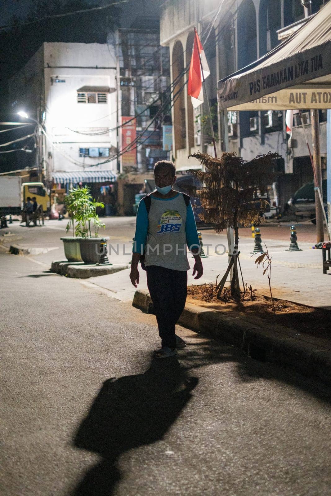 Jakarta, Indonesia - October 4 2023: Man Strolling on the Streets at Night