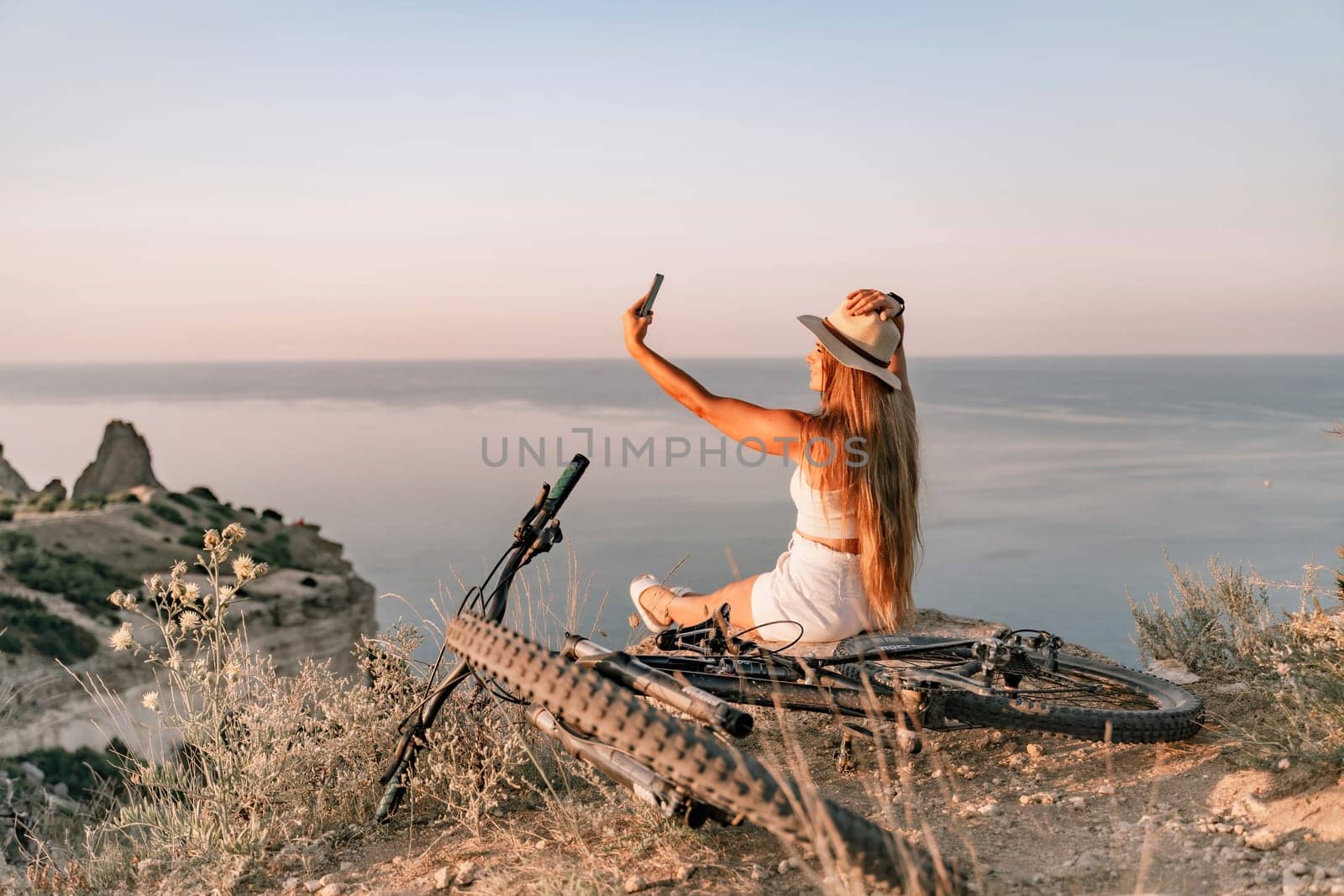 Selfie woman in cap and tank top making selfie shot mobile phone post photo social network outdoors on sea background beach people vacation lifestyle travel concept. by Matiunina