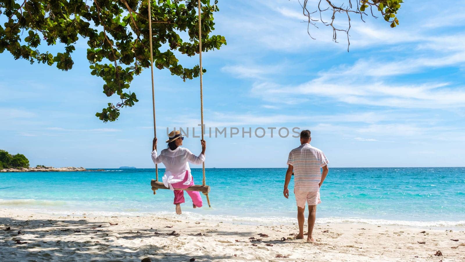 A couple of men and woman at a swing on the beach of Koh Samet I by fokkebok