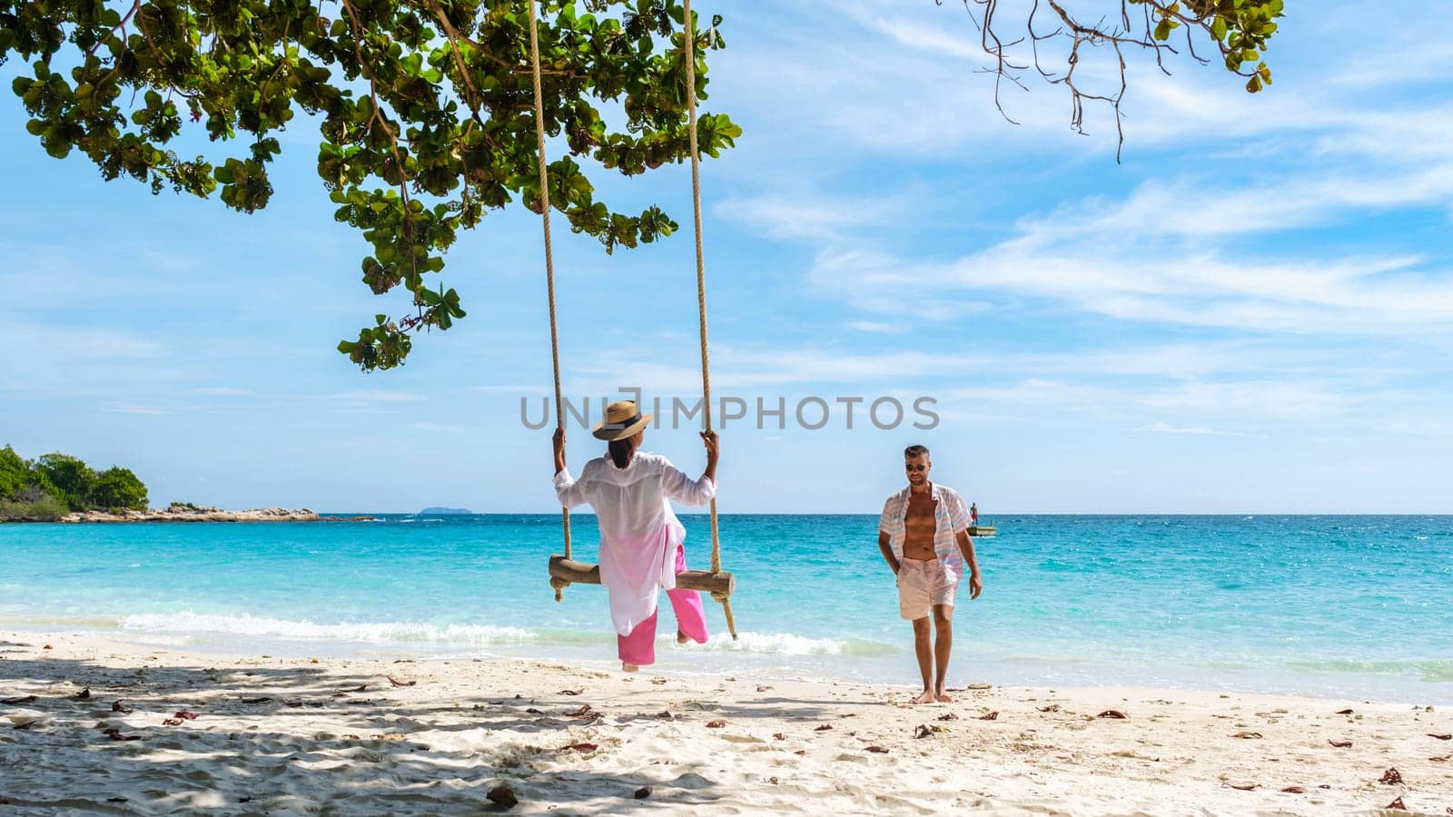 A couple of men and women at a swing on the beach of Koh Samet Island Rayong Thailand, a couple on honeymoon in Thailand