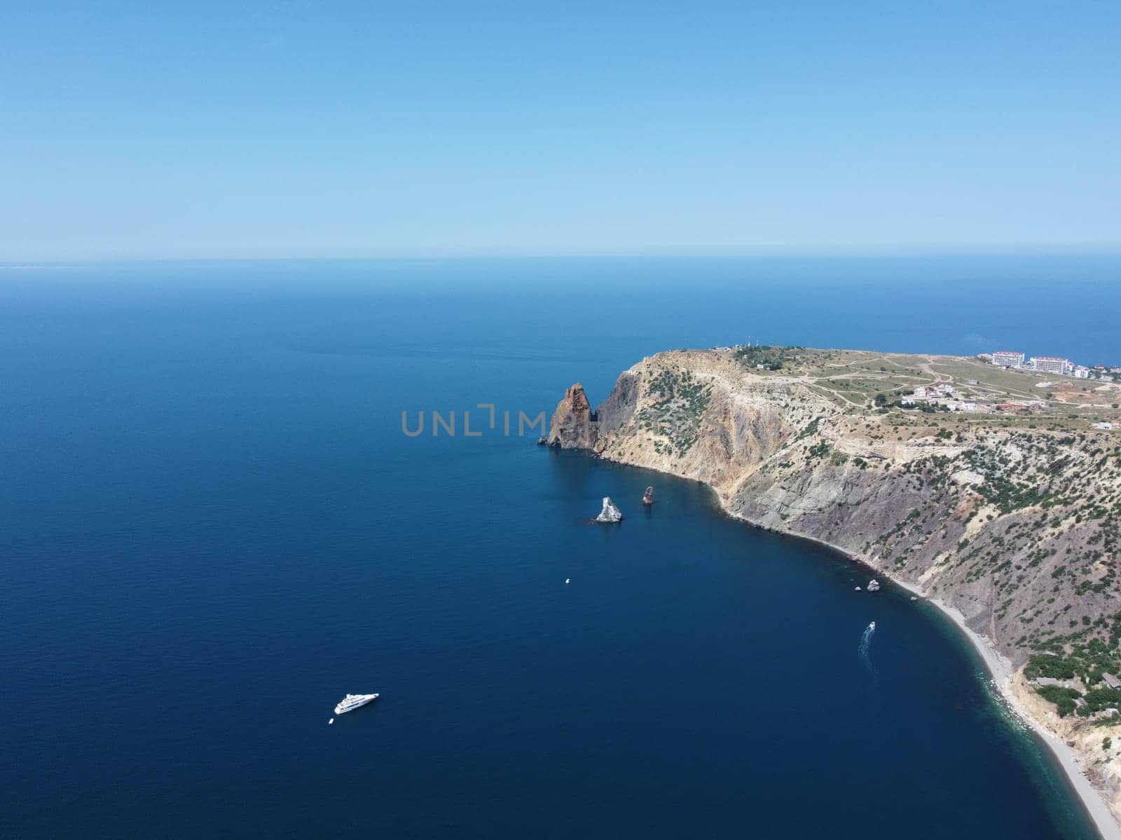 Aerial view from above on calm azure sea and volcanic rocky shores. Small waves on water surface in motion blur. Nature summer ocean sea beach background. Nobody. Holiday, vacation and travel concept by panophotograph