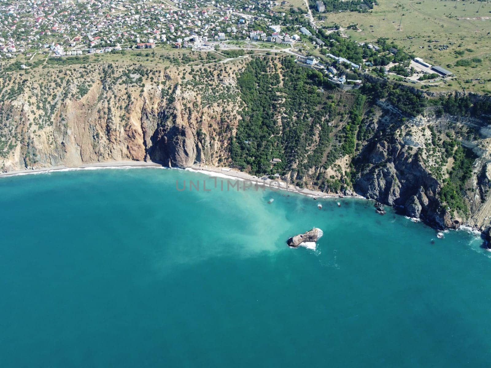 Aerial view from above on calm azure sea and volcanic rocky shores. Small waves on water surface in motion blur. Nature summer ocean sea beach background. Nobody. Holiday, vacation and travel concept by panophotograph