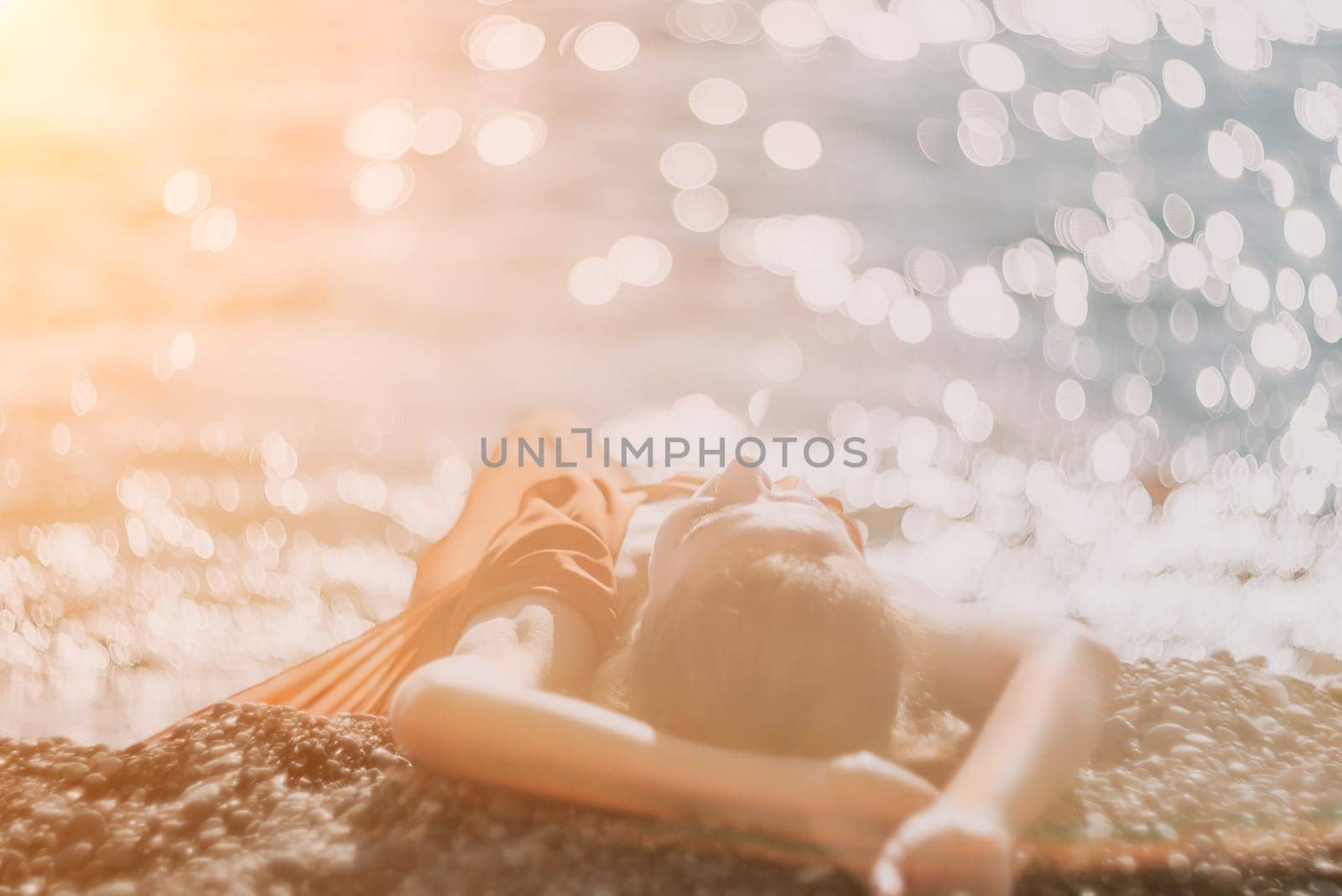 Woman in red dress on sea. Side view a Young beautiful sensual woman in a red long dress posing on the beach near sea on sunset. Girl on the nature on blue sky background. Fashion photo. by panophotograph