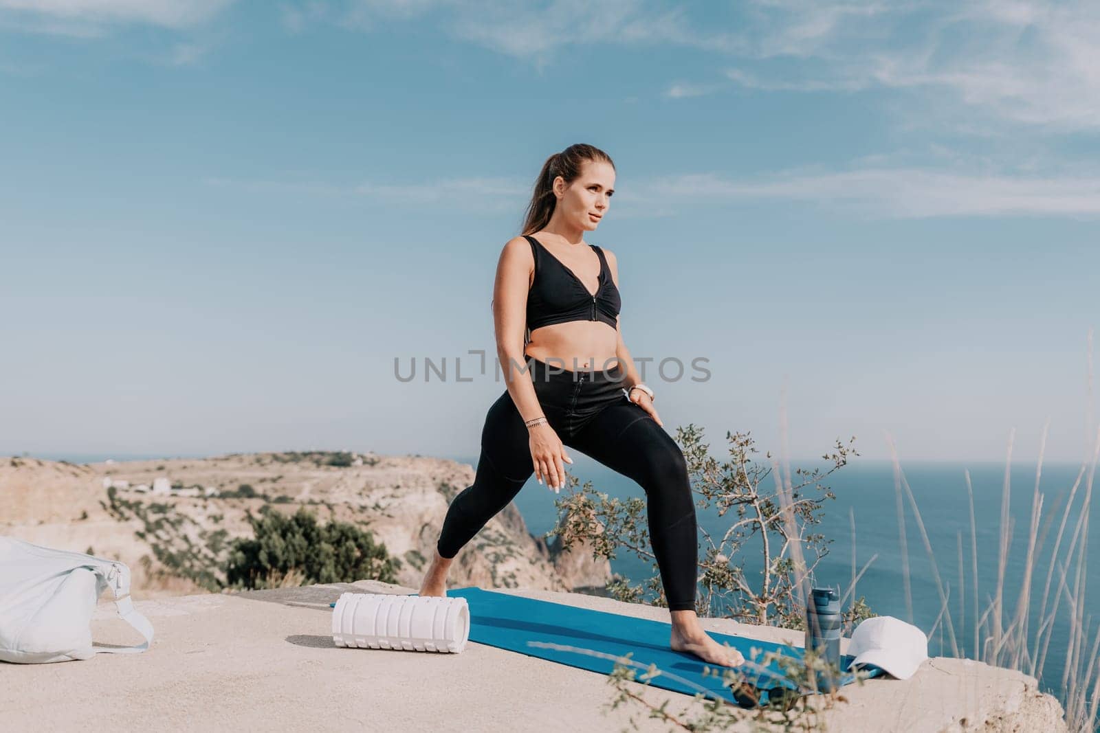 Fitness woman sea. Outdoor workout on yoga mat roller in park near to ocean beach. Female fitness pilates yoga routine concept. Healthy lifestyle. Happy fit woman exercising with rubber band in park. by panophotograph