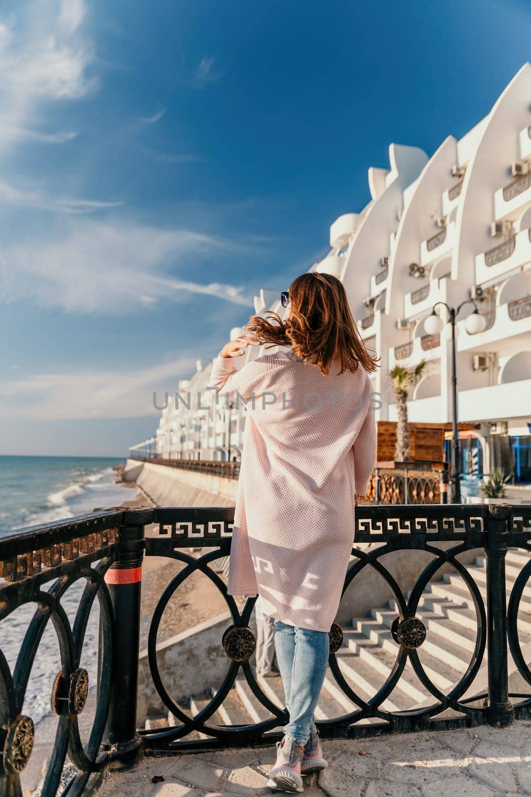 Woman summer travel sea. Happy tourist enjoy taking picture outdoors for memories. Carefree woman traveler posing on beach at sea on sunset, sharing travel adventure journey. Holiday vacation concept. by panophotograph