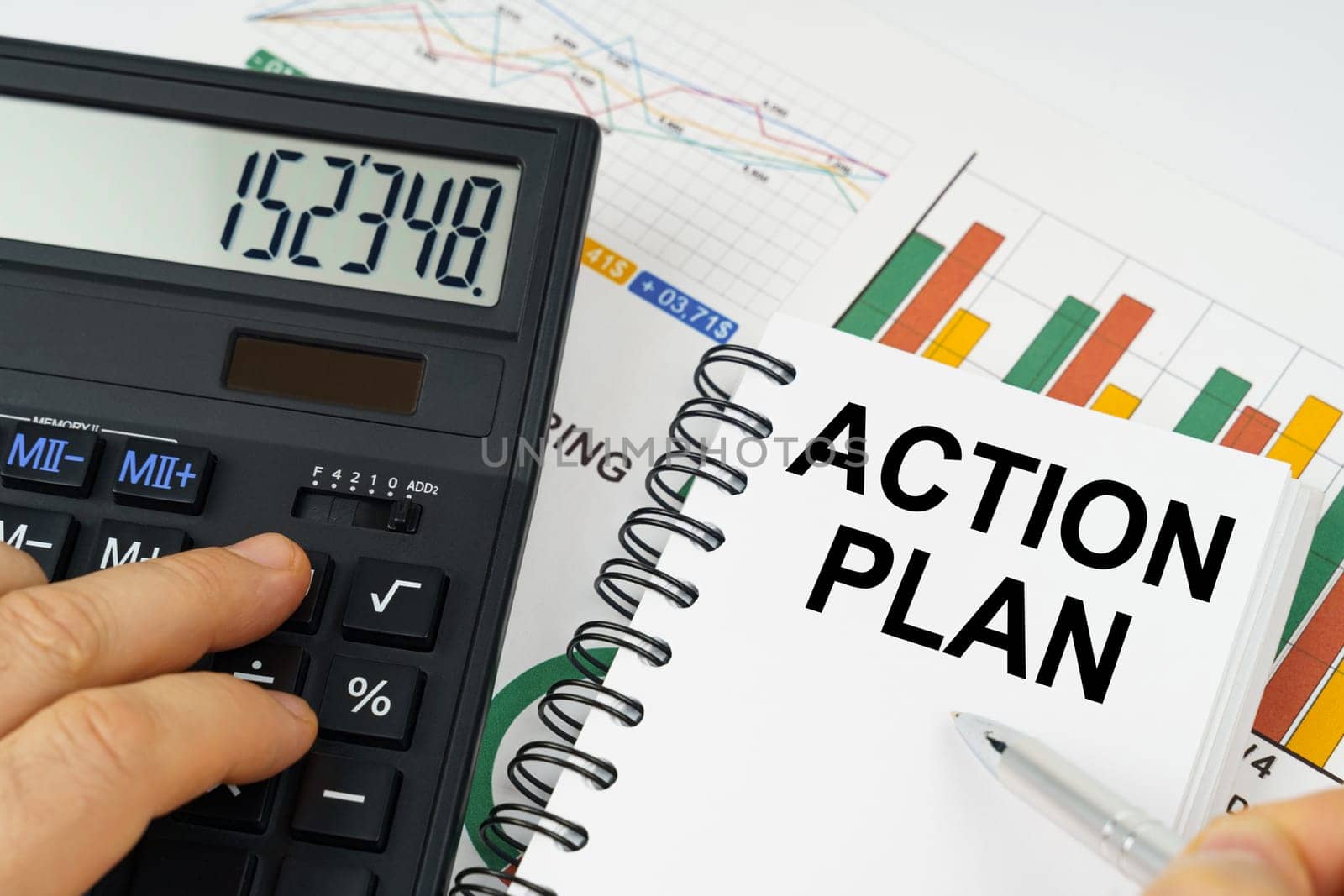 Business concept. On the table there is a calculator, reports with graphs and a notepad with the inscription - ACTION PLAN
