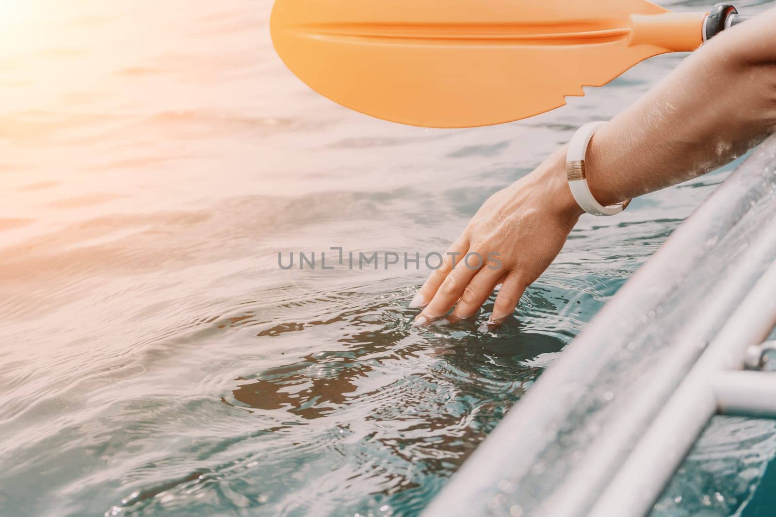 Woman in kayak back view. Happy young woman with long hair floating in transparent kayak on the crystal clear sea. Summer holiday vacation and cheerful female people relaxing having fun on the boat by panophotograph