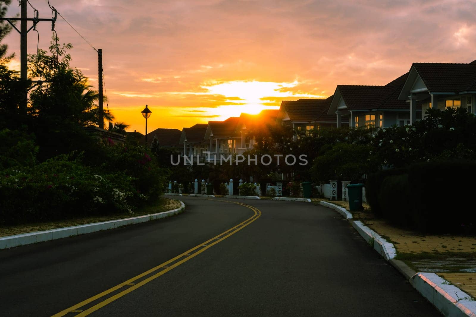 Modern cottages row road sidewalk two story buildings residential villas village New Estate Reflection dawn Sun in windows.