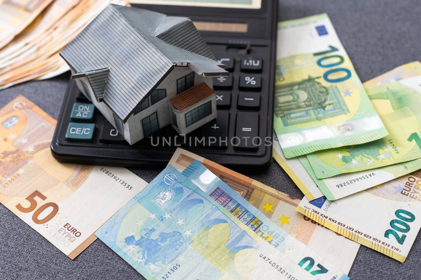 Layout of a house, banknotes , calculator lying on the table. Insurance, credit, mortgage, real estate purchase . Payment of interest on the mortgage. High quality photo