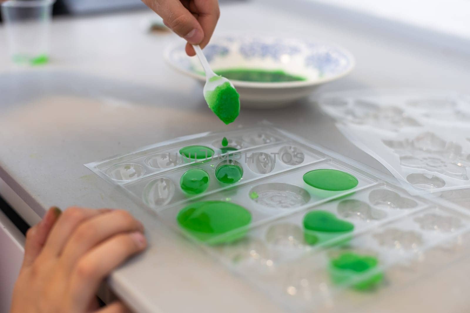 child learning research and doing a chemical experiment while making analyzing and mixing liquid in test glasses. Playful little girl in protective wear having fun playing with chemistry lab game by Andelov13