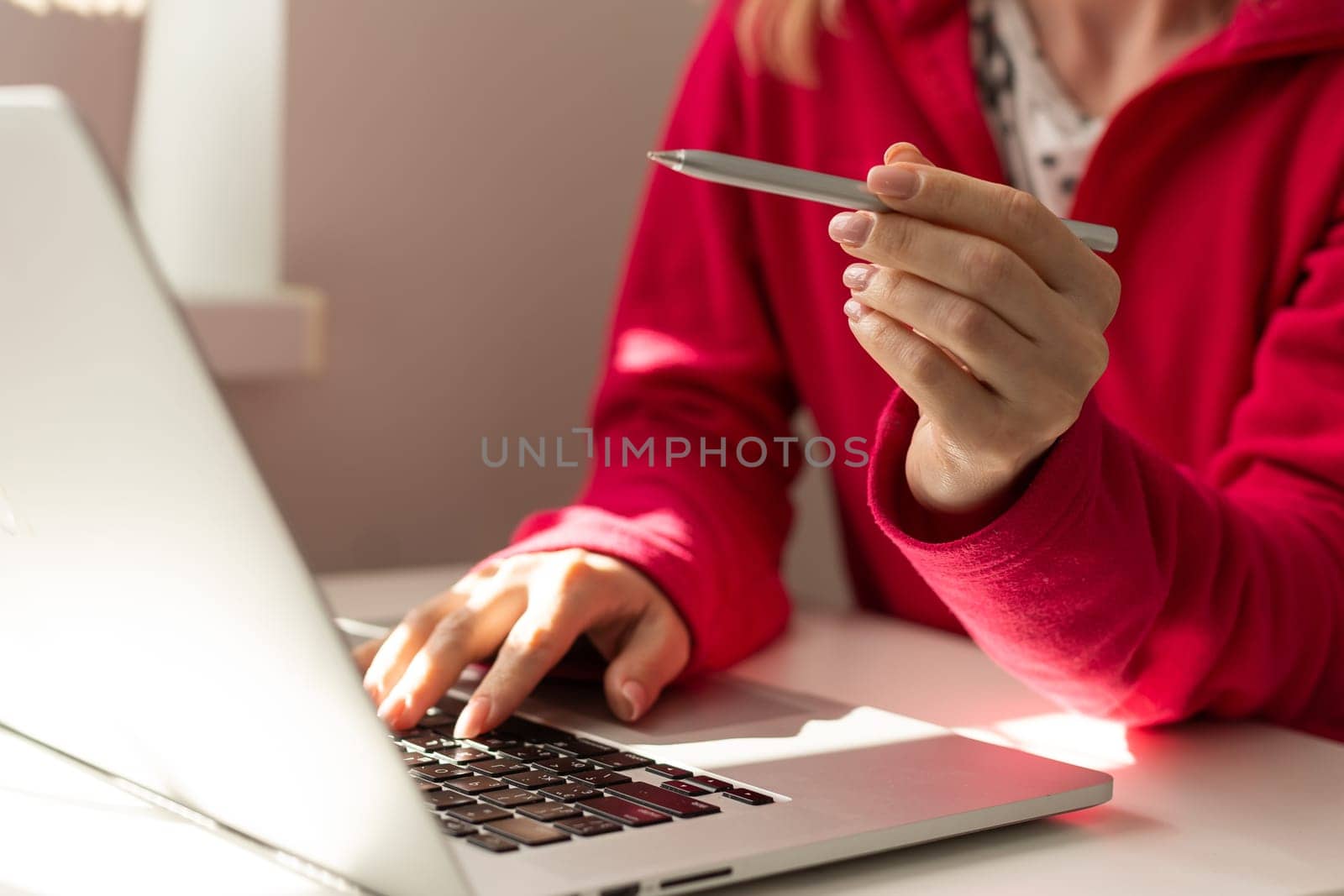 Hand of freelancer pointing on laptop screen with pen at desk. by Andelov13