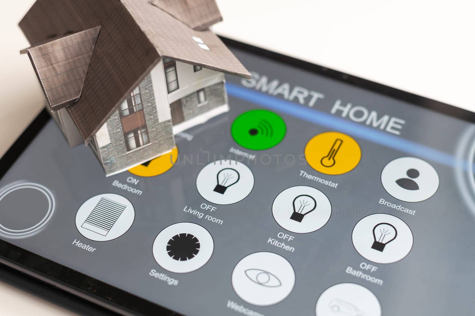 Small house model is on screen tablet and icons home electronics devices connecting with wireless. Smart home controlled and Automation system technology of things