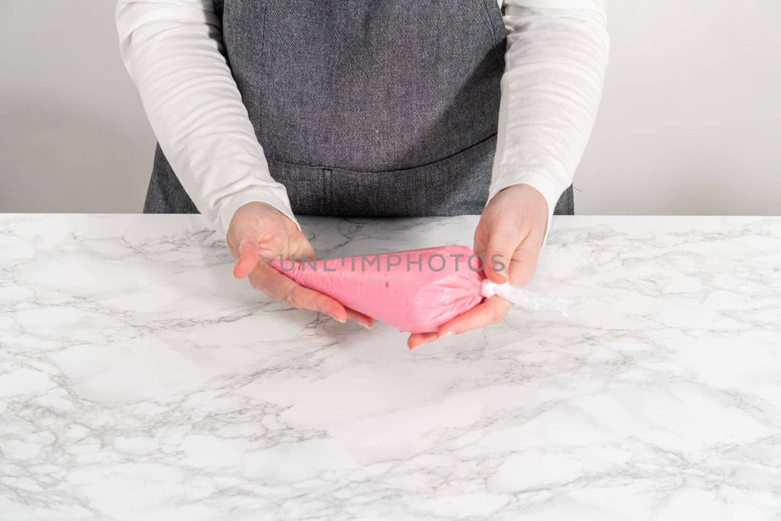 Homemade royal icing in piping bags ready to decorate sugar cookies on the kitchen counter.