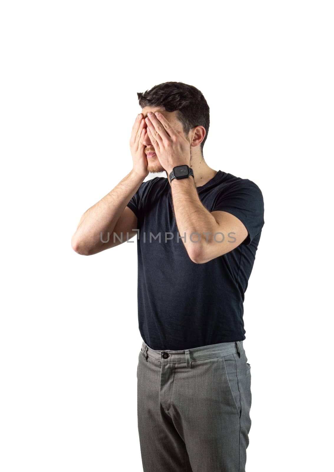 Attractive young man covering eyes with his hands in studio shot. Secret concept. Isolated on white