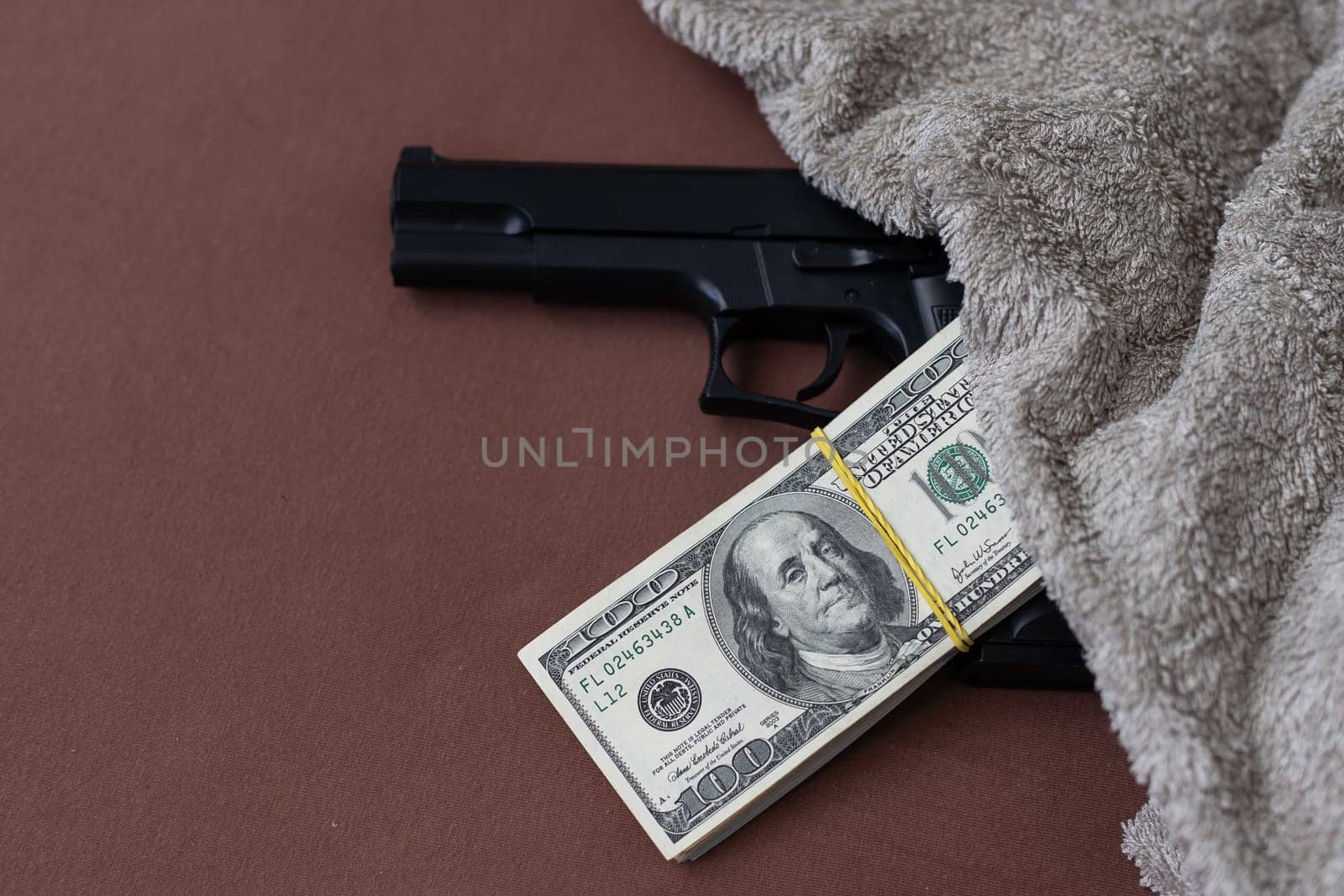 Pile of US dollar cash and a black pistol gun. Seen from above. High quality photo