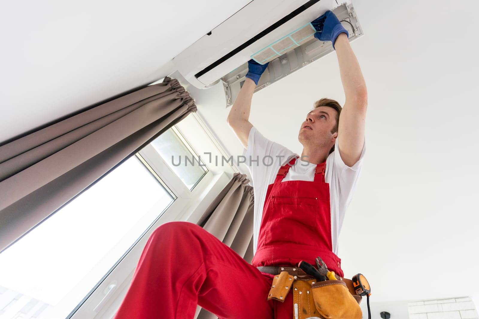 technician service removing air filter of the air conditioner for cleaning