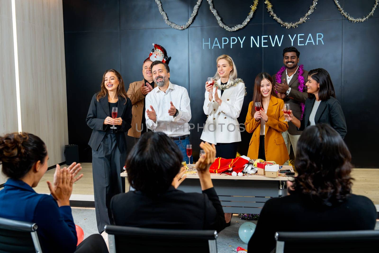 Caucasian business man stand on stage with his staffs to say or bless or encourage the employee in the company during new year celebraion.