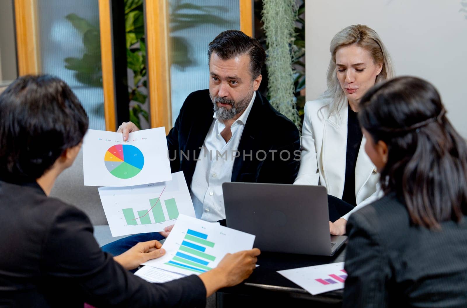 Close up of Caucasian business man look like manager explain about his work using graph on paper to the colleagues.